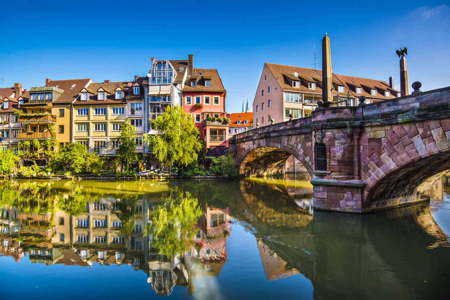 Untere Karlsbrücke, rötlich schimmernd, sehr ruhiges, spiegelndes Wasser der Pegnitz, wolkenloses Himmel; Kurtz Detektei Nürnberg