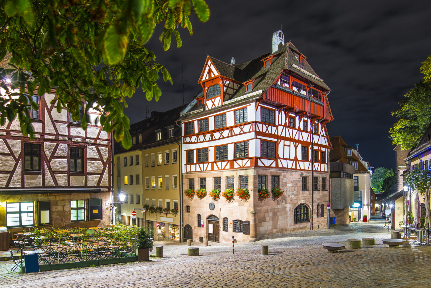 Nächtliche Aufnahme der angestrahlten Gebäude am Tiergärtnerplatz in Nürnberg, Fachwerkhäuser und ein Turm; Detektive der Kurtz Detektei Nürnberg